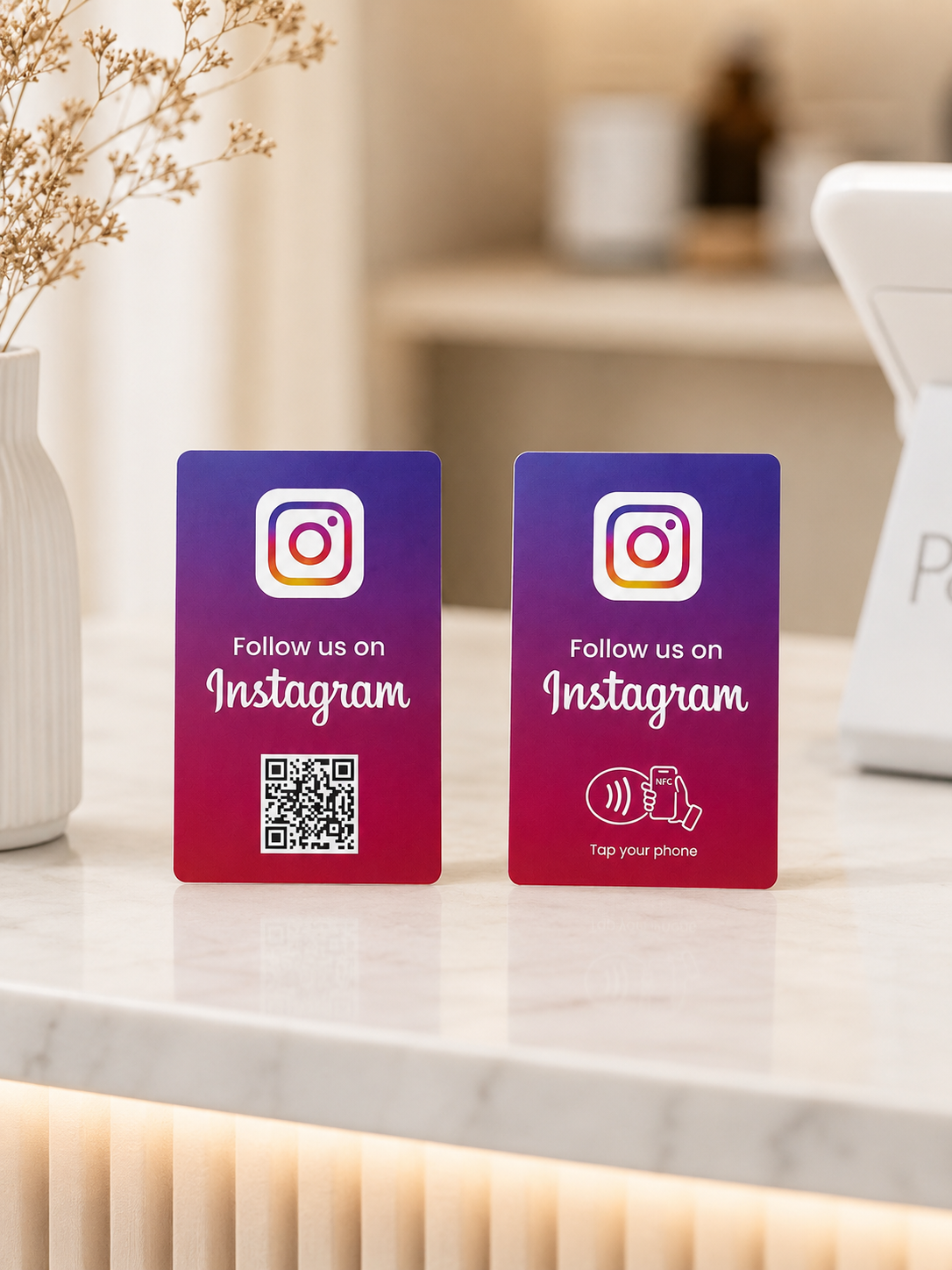 Due card NFC Instagram sul bancone: una con QR code e una con simbolo NFC Tap your phone