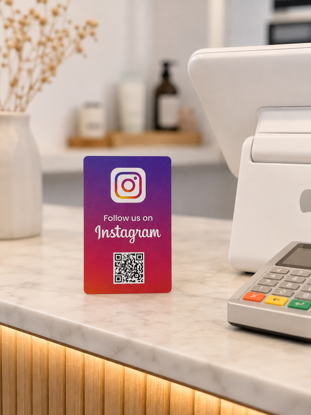 Card NFC Instagram appoggiata sul bancone di marmo accanto al POS, scritta Follow us on Instagram
